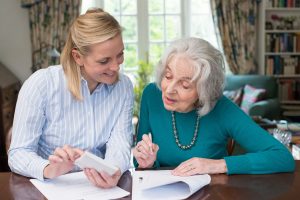 Woman Helping Senior Parent with Estate Paperwork such as Power of Attorney.